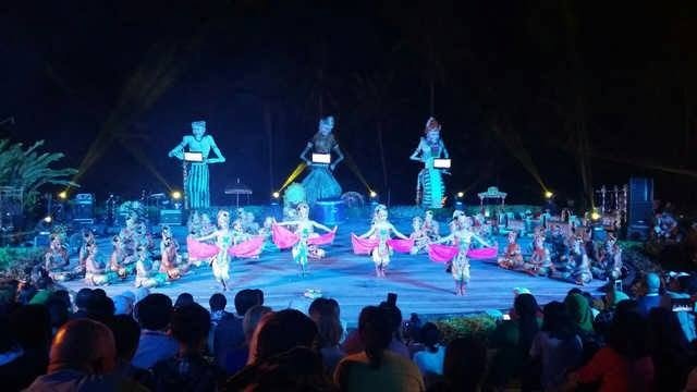 Pertunjukan tari budaya di panggung terbuka pada malam hari